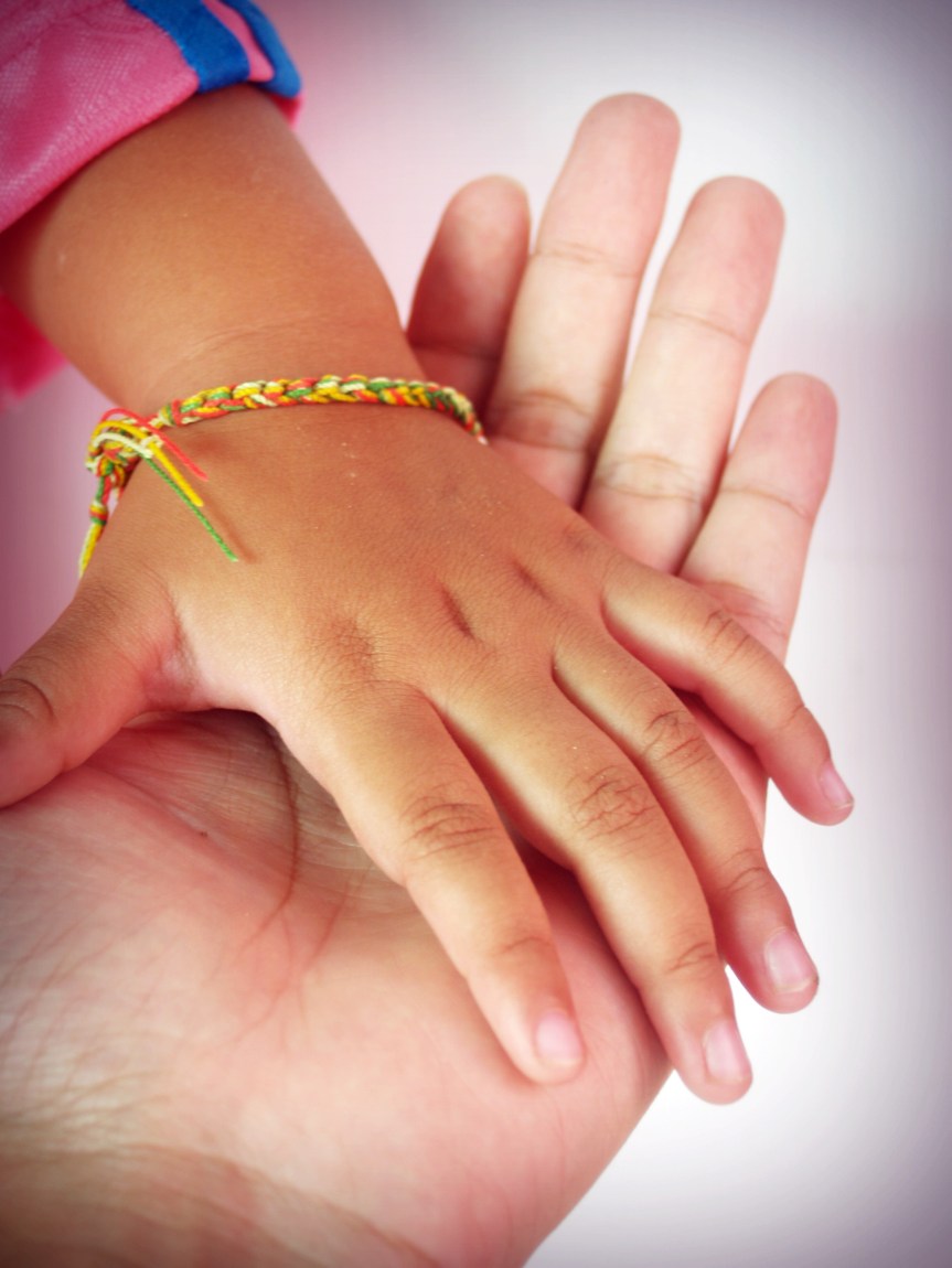 Hands holding the hand of a younger